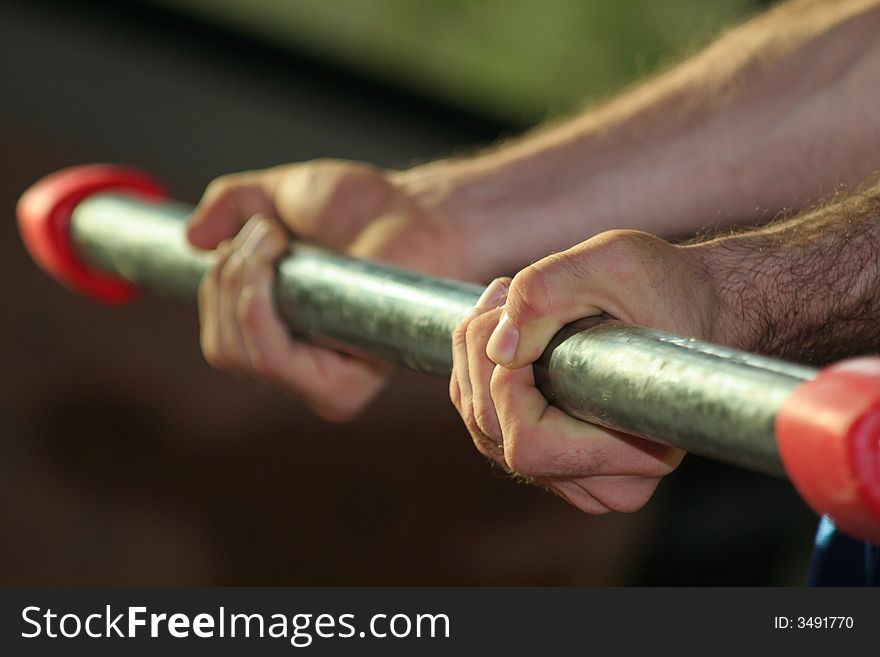 Two hands held close a body bar / Exercises in the gym. Two hands held close a body bar / Exercises in the gym