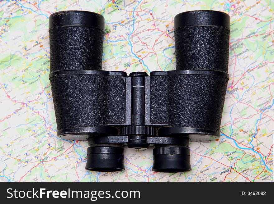 A black binoculars and a map. A black binoculars and a map