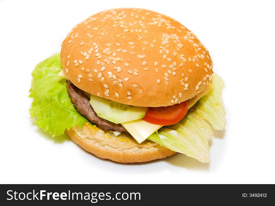 A cheeseburger with cucumber, tomatoes and salad. A cheeseburger with cucumber, tomatoes and salad