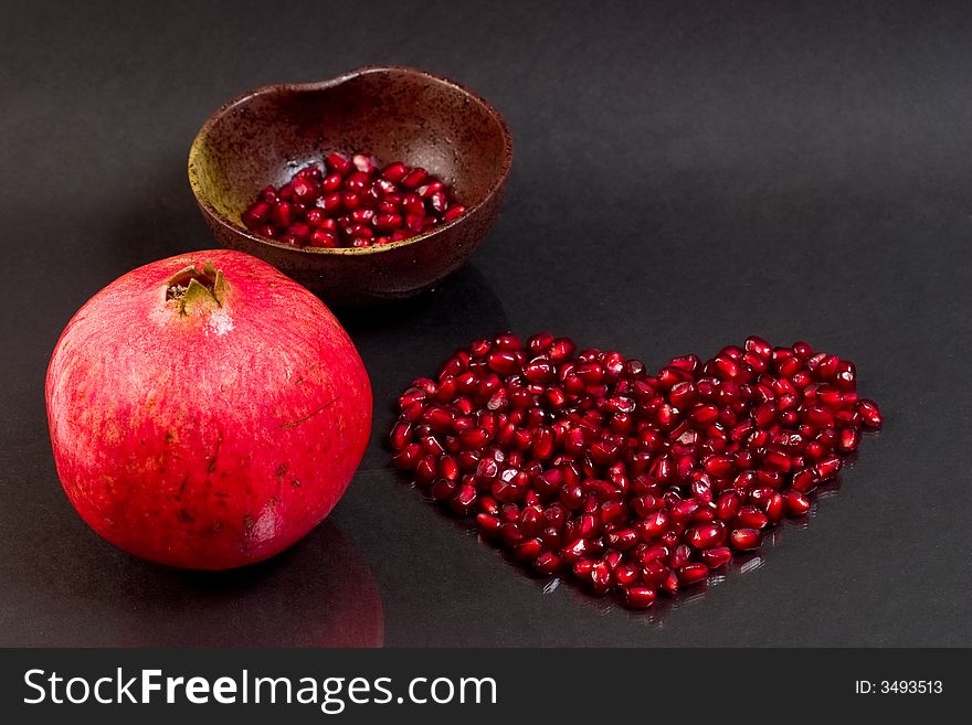 Pomegranate seeds laid out in a heart  shape