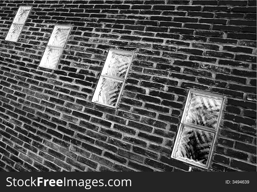 Four windows in a brick wall in black and white