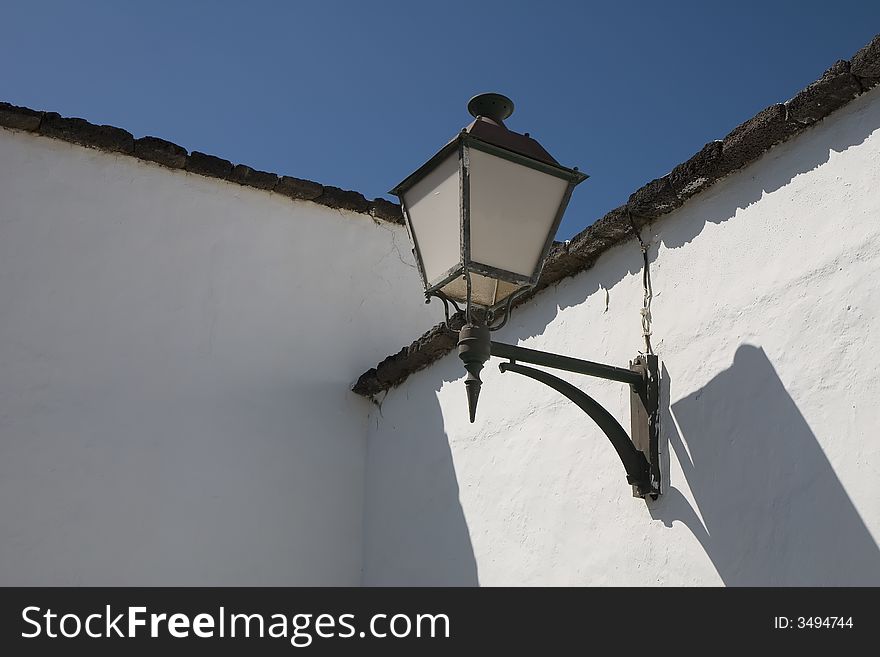 A street lamp on a whitewashed wall