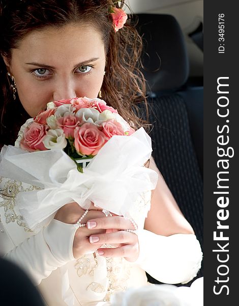 Beautiful young bride sitting in the car