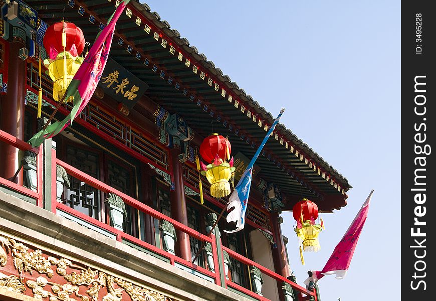 Front of a chinese house with three red and yellow lanterns. Front of a chinese house with three red and yellow lanterns