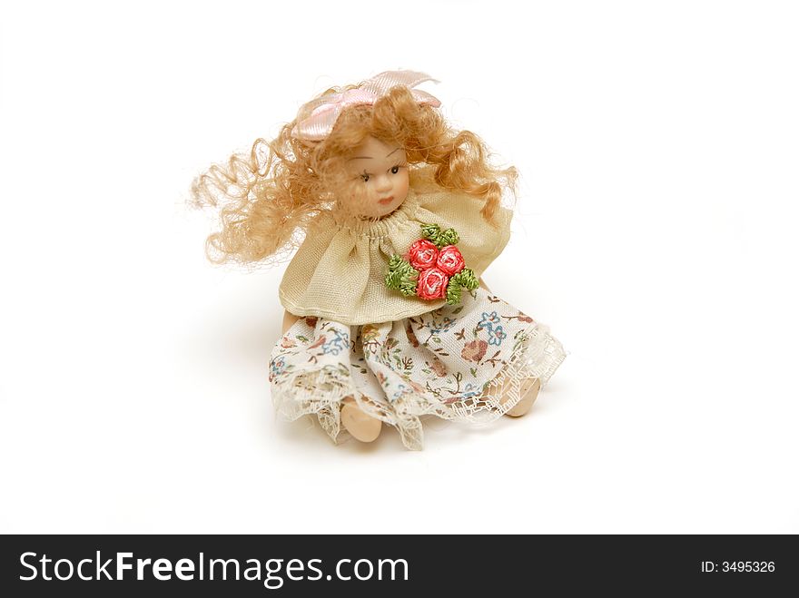 Small sitting ceramic dolly on white background. Small sitting ceramic dolly on white background
