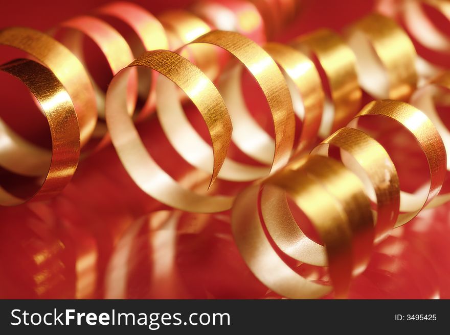 Golden curly ribbons on red background. Golden curly ribbons on red background