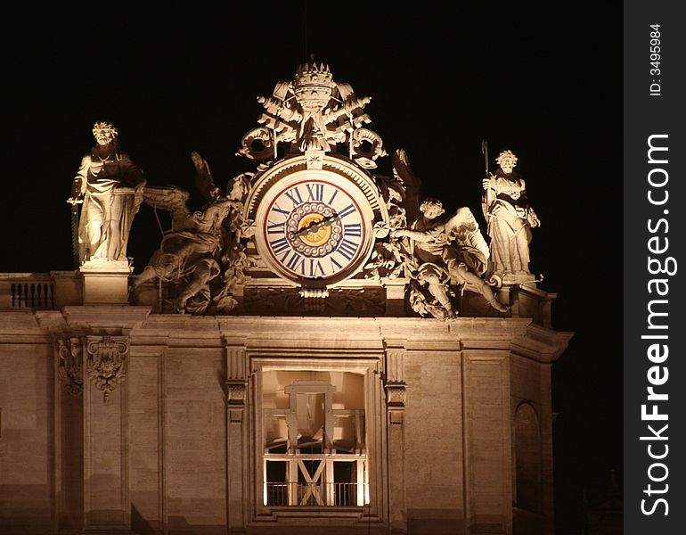 St. Peter's (Rome - Italy - Vatican City) Left side with clock and two sculptures by side at night / Evocative lights on the house of the Pope and Christians. St. Peter's (Rome - Italy - Vatican City) Left side with clock and two sculptures by side at night / Evocative lights on the house of the Pope and Christians