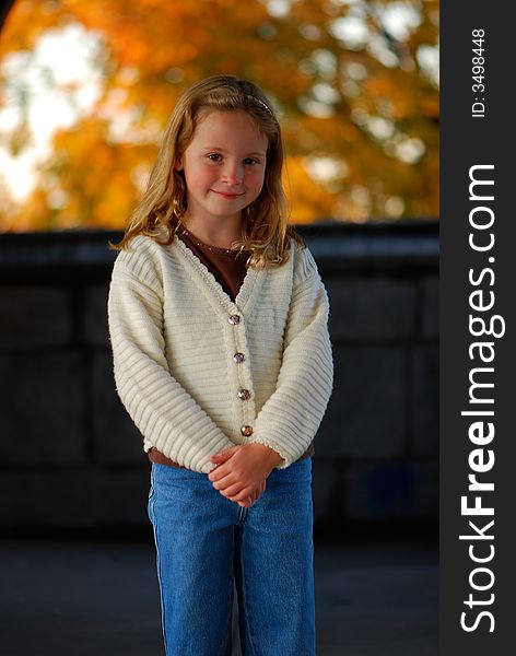 A pretty little girl with a sweet smile poses for an outdoor portrait. A pretty little girl with a sweet smile poses for an outdoor portrait.