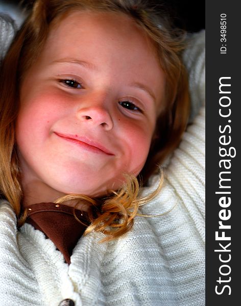 A pretty little girl with a sweet smile poses for an outdoor portrait. A pretty little girl with a sweet smile poses for an outdoor portrait.