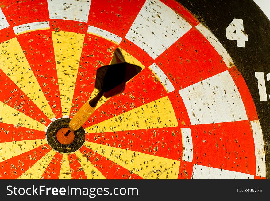 Dartboard with single dart in the middle or bulls -eye.  symbol of hitting the target or making the goal