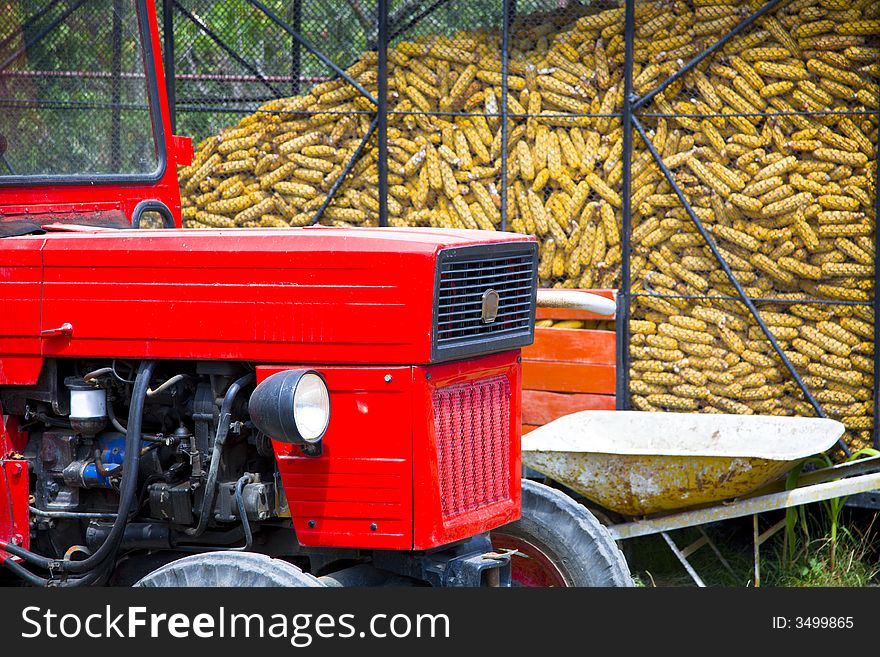 Tractor parked at a farm in front of a corn silo