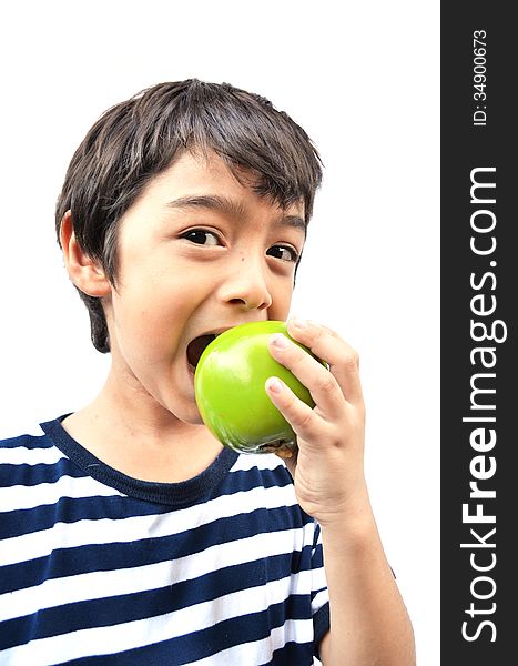 Little boy eating green apple on white background