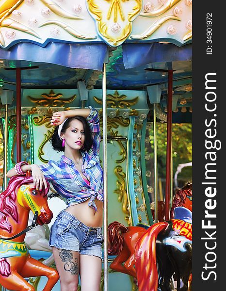 Merry-go-round. Playful Stylish Showy Woman In Roundabout. Funfair