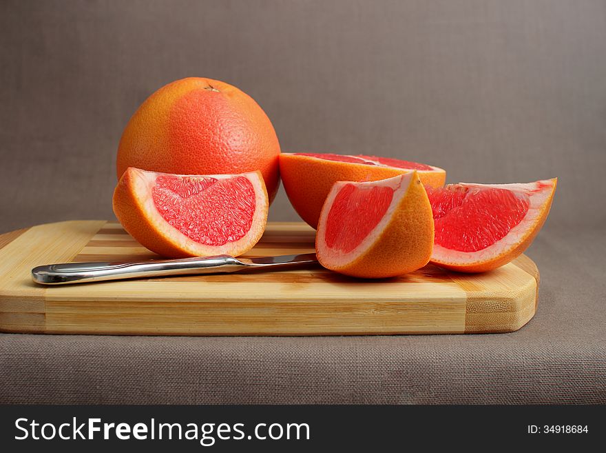 Grapefruit cut into pieces on a cutting board. Grapefruit cut into pieces on a cutting board