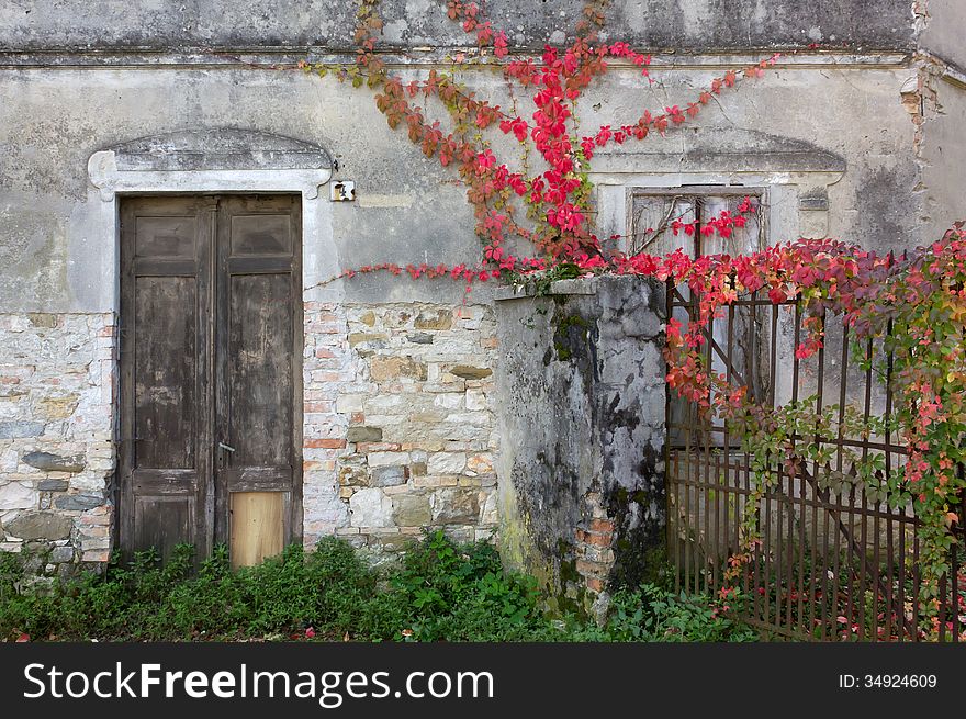 Front door and gate of an old building in autumn