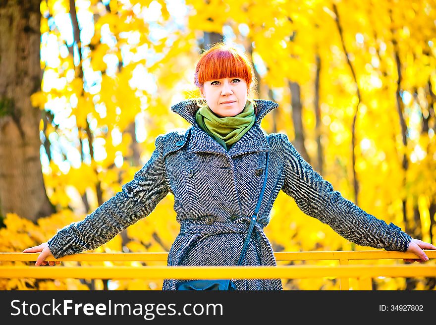 Woman in a coat walks on autumn park