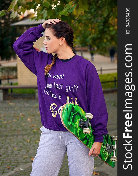 Beautiful young woman on the city with skateboard. Beautiful young woman on the city with skateboard