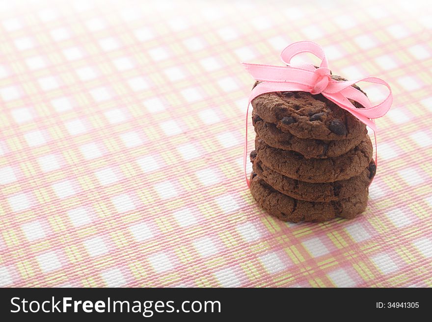 Chocolate Cookies with pink tape at pink napkin. Chocolate Cookies with pink tape at pink napkin