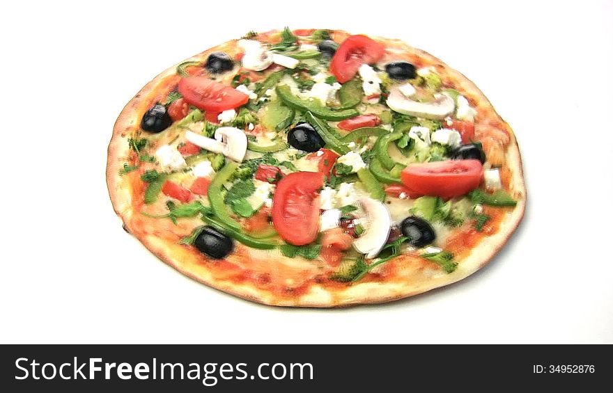 Vegetarian pizza rotate, showing all of its stuffing: peppers, olives, tomatoes, mushrooms, feta cheese, mozzarella