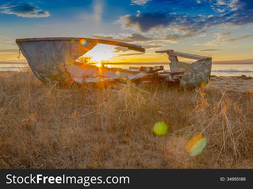 The rays of the setting sun against the background of an old boat. The rays of the setting sun against the background of an old boat