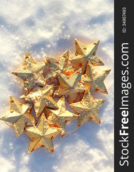 Golden christmas stars in the snow in sunny winter day. Golden christmas stars in the snow in sunny winter day