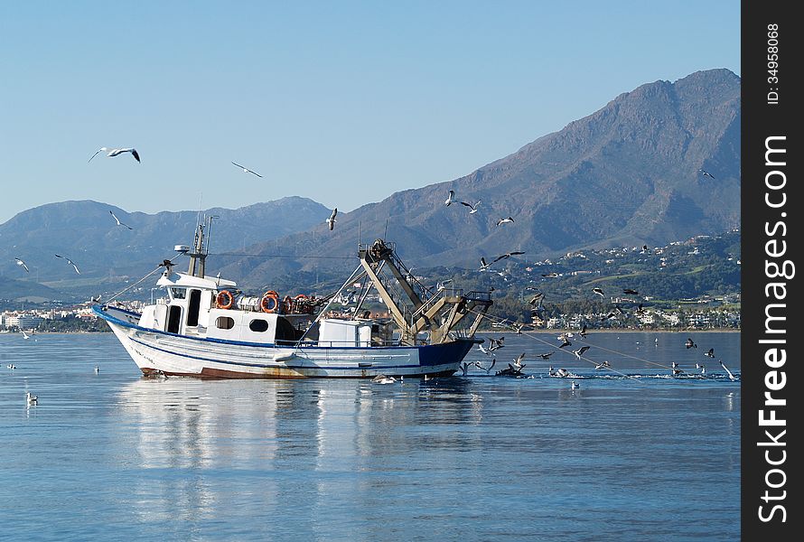 Fishing boat pulling the trawl. Mediterranean coast of Spain.