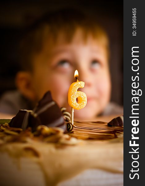 The boy looks at the birthday cake. The boy looks at the birthday cake