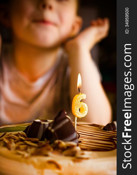 The boy looks at the birthday cake. The boy looks at the birthday cake