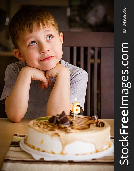 The boy looks at the birthday cake. The boy looks at the birthday cake