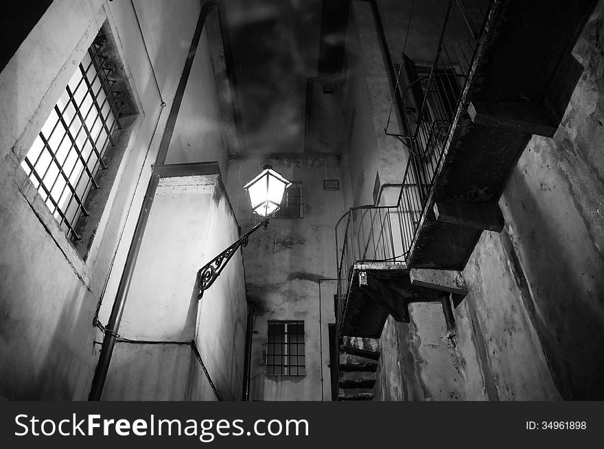 Spooky night scene with street light, stairs and smoke during rainy