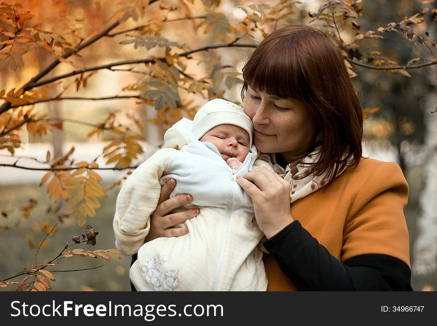 Newborn on the mother hands in the park in autumn. Newborn on the mother hands in the park in autumn