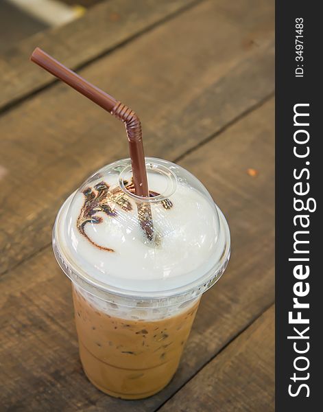 Iced coffee on the wooden table in the garden of coffee shop.