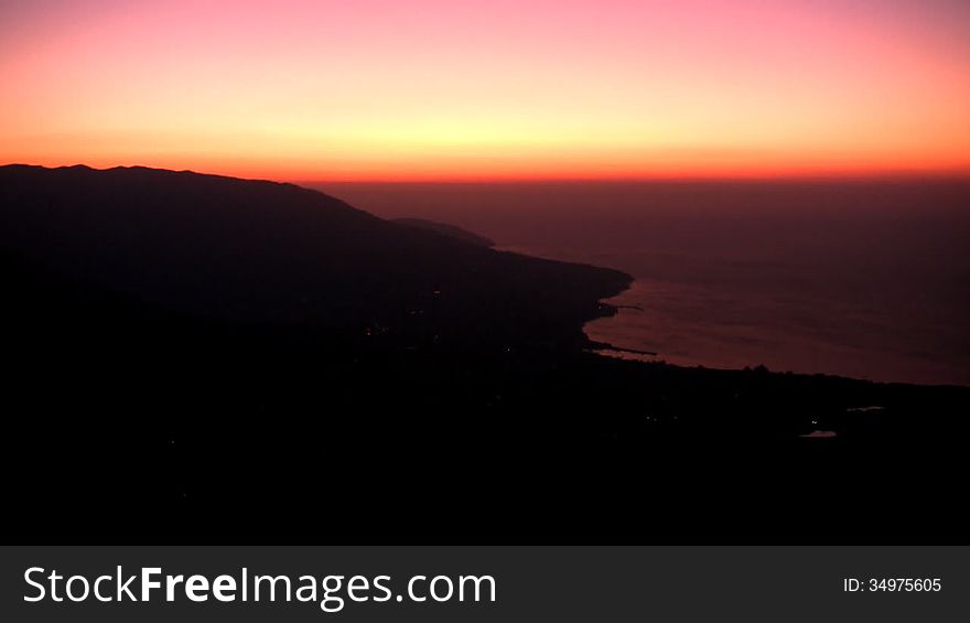 Sea. Mountains. Predawn twilight. The sun rises over the sea on the background of a cloudless sky. Timelapse. Sea. Mountains. Predawn twilight. The sun rises over the sea on the background of a cloudless sky. Timelapse