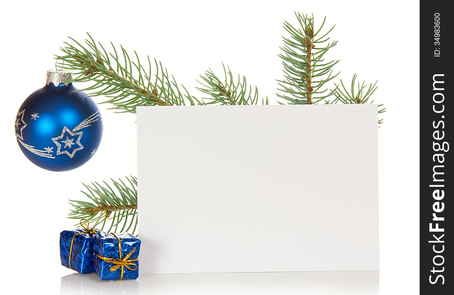 Fir-tree branch with a Christmas toy, souvenirs and a card isolated on white. Fir-tree branch with a Christmas toy, souvenirs and a card isolated on white