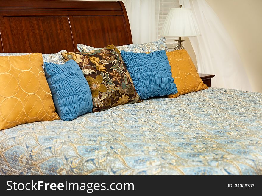 Decorative bedroom with king headboard and colorful linens