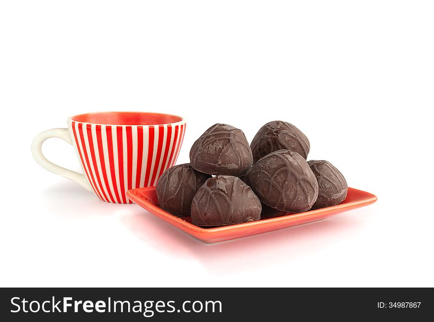 Chocolate candies with cup of tea on a white background. Chocolate candies with cup of tea on a white background