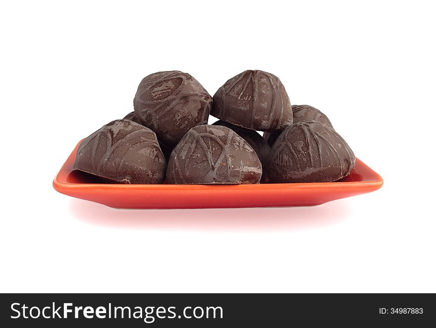 Chocolate candies on a plate at a white background