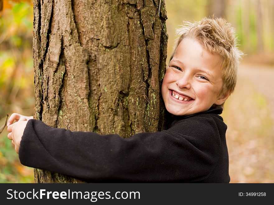 Kid in a forest hugging a tree. Kid in a forest hugging a tree