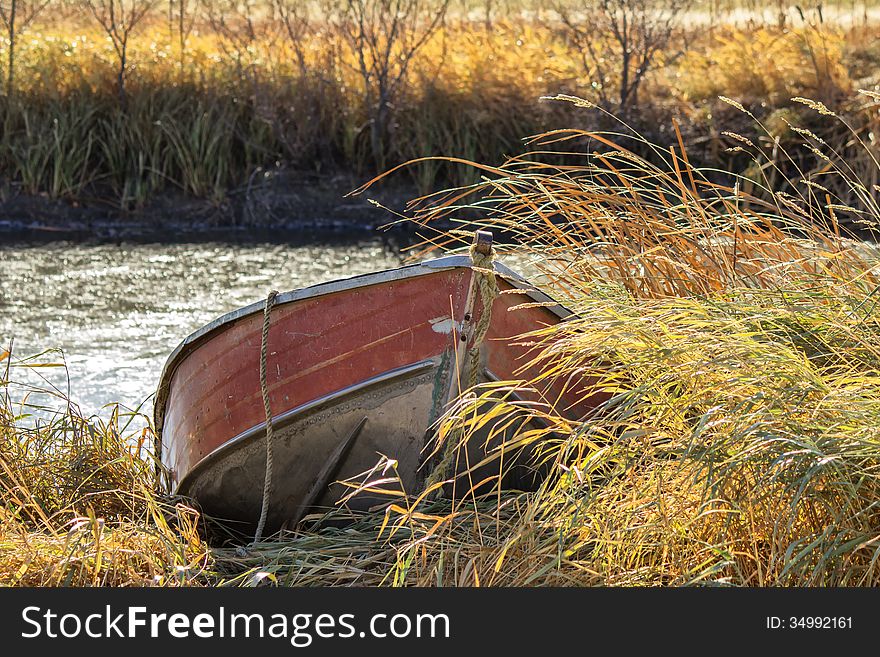 A Red Canoe Docked In Tall Grass