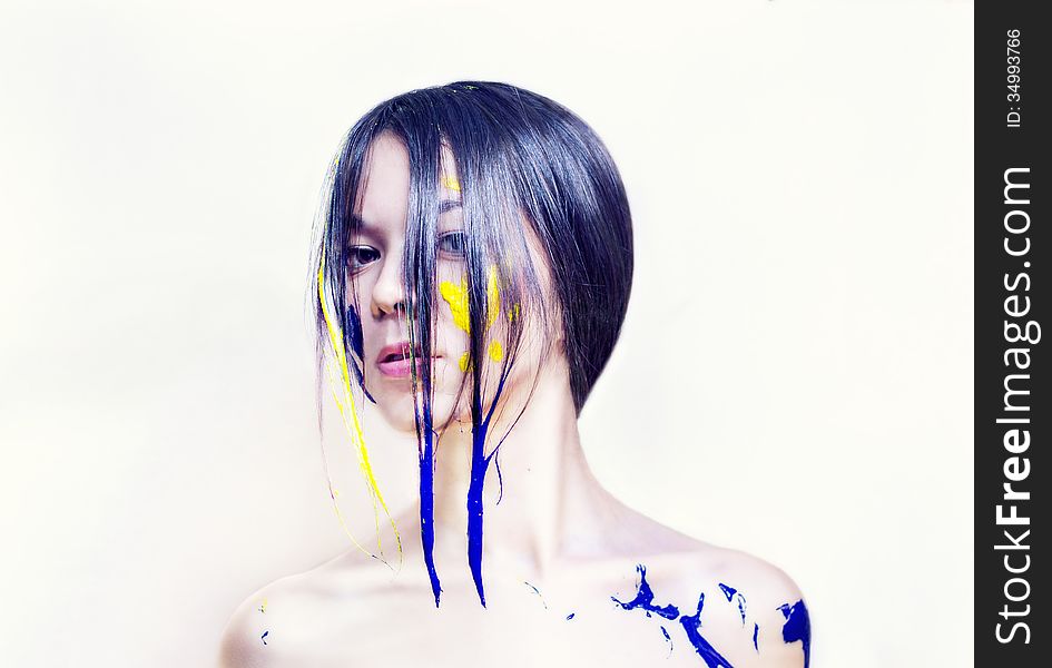 Beauty face of a girl painted blue and yellow