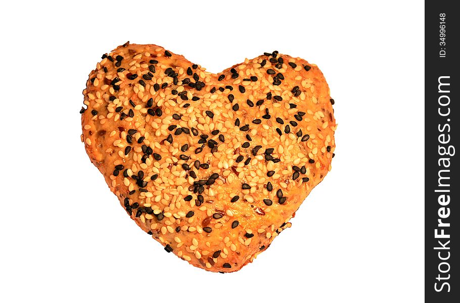 A heart-shaped home-made bread topped with black and white sesame seeds, on a white background. A heart-shaped home-made bread topped with black and white sesame seeds, on a white background