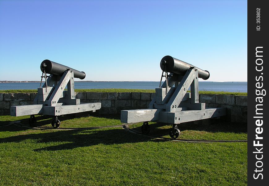 A pair of vintage military cannons facing the sea. A pair of vintage military cannons facing the sea.