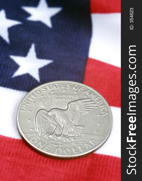 One dollar coin and american flag