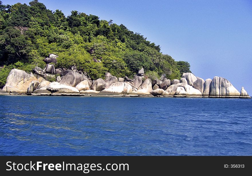 Beautiful landscape of a tropical island. You can see lines of water level due to low tide on the rocks. Beautiful landscape of a tropical island. You can see lines of water level due to low tide on the rocks