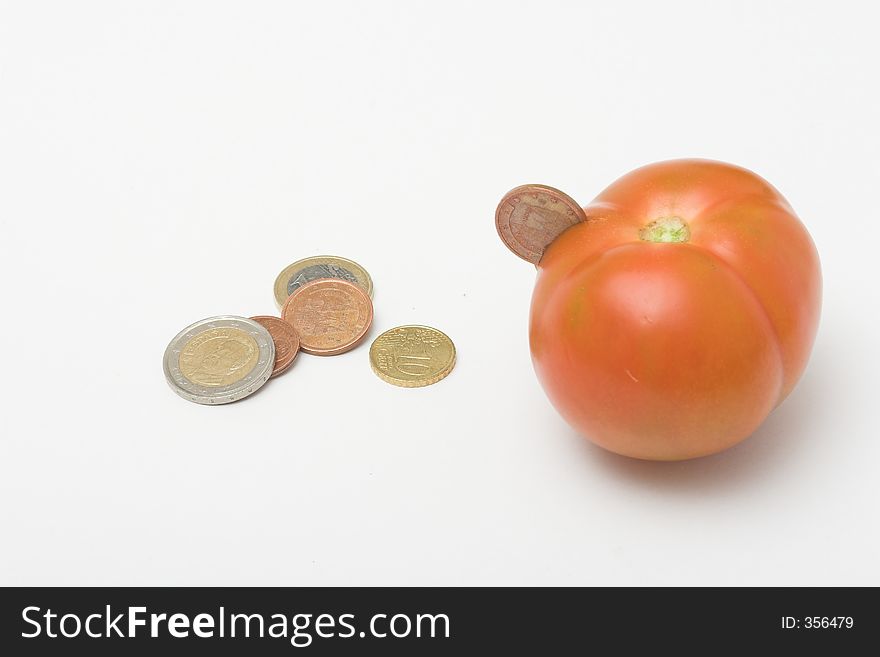 Euro coins inserted in tomato. Euro coins inserted in tomato