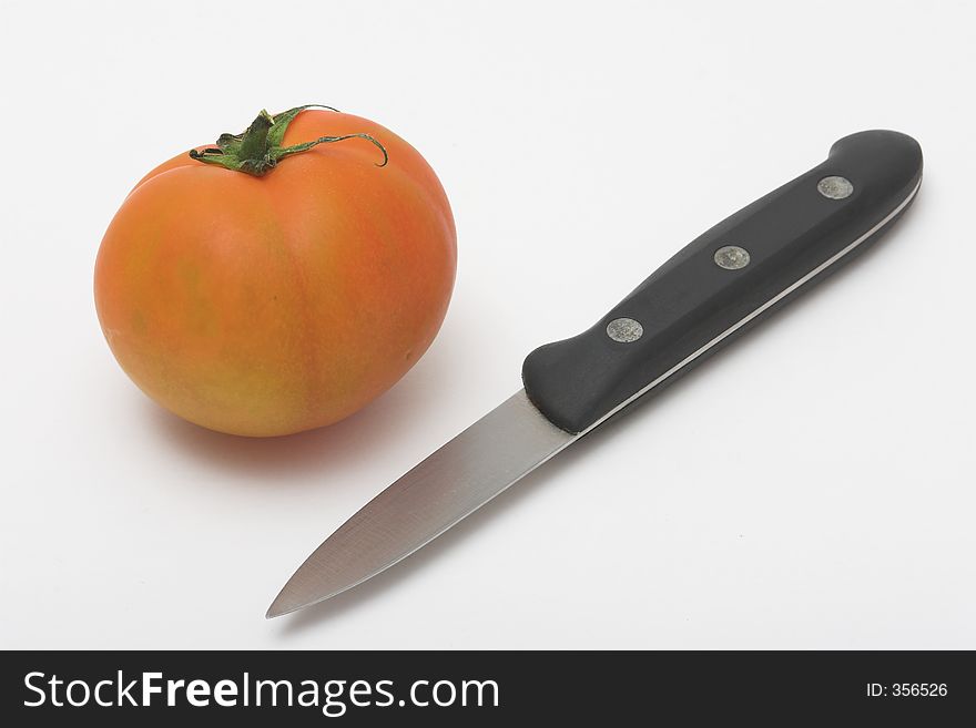 Tomato and knife in a white background
