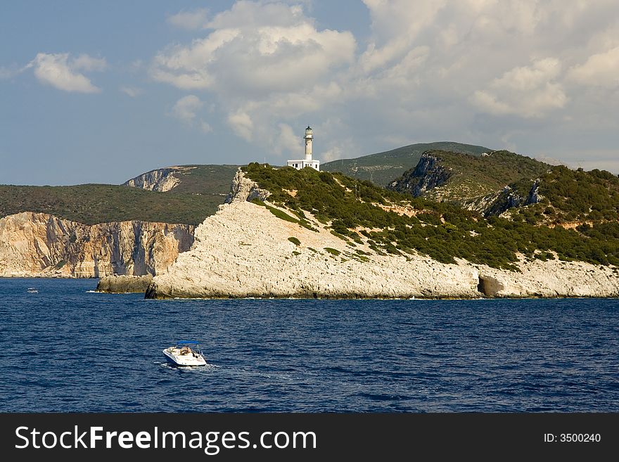 Glittering white rocks on the wild coast of Greek island Lefkada are bathed by water of Ionian Sea. Cape Lefkatas is the southernmost point of the island and it gave the name to whole island.