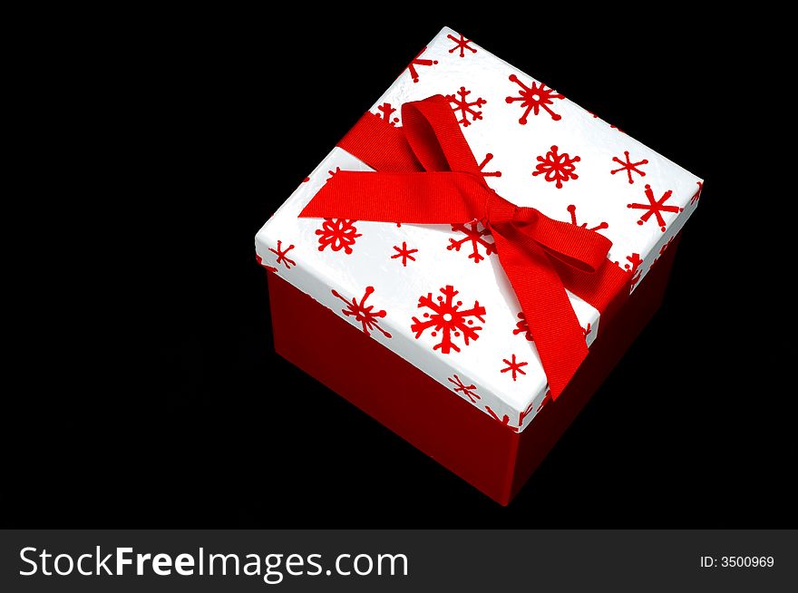 Red and white gift box on black background with copy space