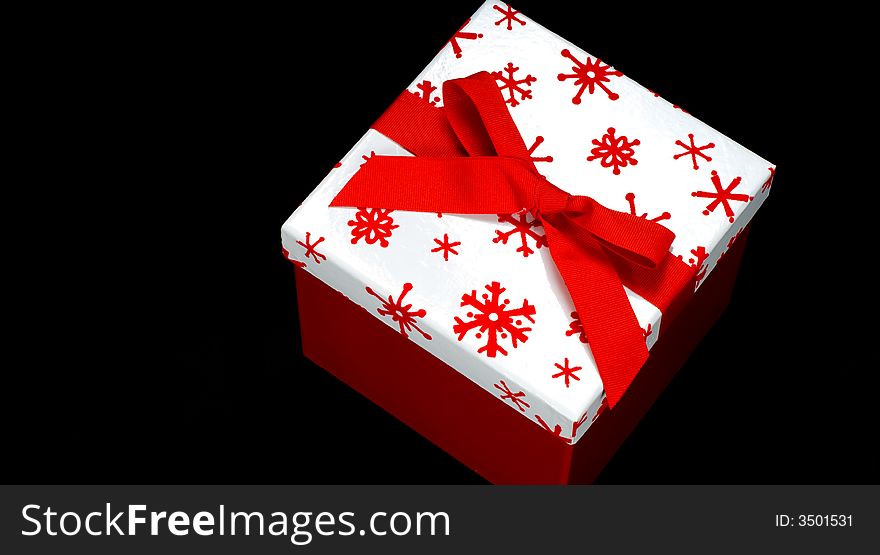 Red and white gift box on black background with copy space