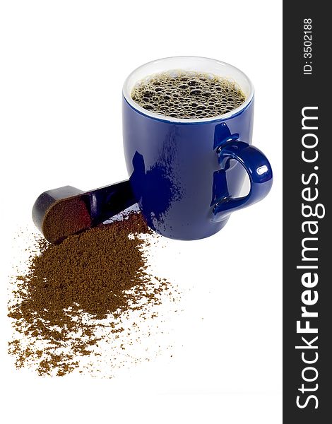 A coffee cup and a spoon spilling coffee powder